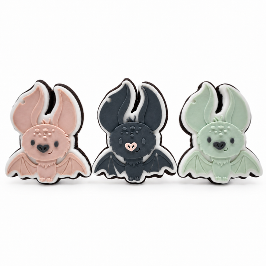 Three Midnight Cocoa bat fondant sugar cookies in blush, charcoal and sage on a white background.
